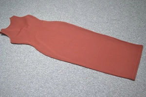 Close-up of the ribbed knit fabric texture and side slit on the rust red bandage dress