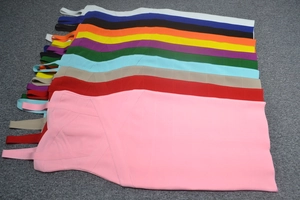 Flat lay display showing 12 vibrant colors of bandage dresses with textured strap design