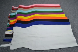 Flat lay of bodycon bandage dresses in eleven vibrant colors with ribbed textures