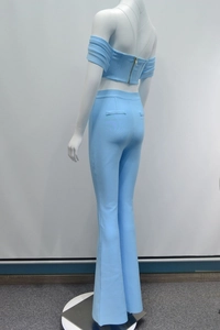 Dettaglio del crop top celeste con spalle scoperte e cerniera in metallo dorato sul retro