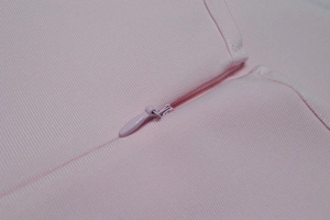Dettaglio della cerniera invisibile e delle cuciture di un abito aderente rosa