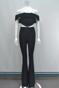 Dettaglio del crop top nero con spalle scoperte e pantaloni a zampa a vita alta a coste