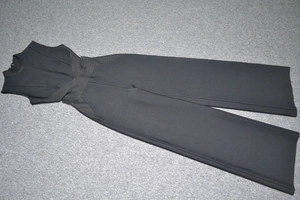 Détail d'une combinaison noire sans manches avec découpe taille et jambe large