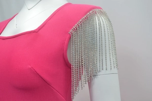 Detail of rose red bandage dress featuring padded shoulders and sparkling rhinestone tassels