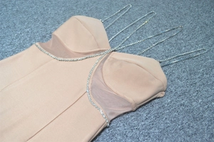Dettaglio dell'abito aderente color nudo con spalline in cristallo e strass