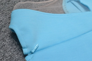 Détail de la fermeture éclair invisible et du tissu mesh sur cette robe bleu clair élégante