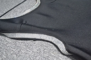 Close-up of black bandage dress featuring shimmering silver sequin trim and knit texture
