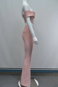 Dettaglio del crop top rosa con spalle scoperte, volant e pantaloni a zampa coordinati