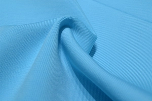 Gros plan détaillé sur la texture du tissu en maille bleu ciel et ses plis doux