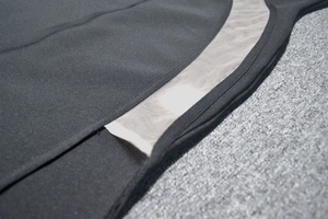 Detailed macro view of the black knit fabric with sheer mesh panel on the bandage dress