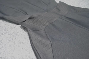 Gros plan d'une combinaison bandage noire avec texture côtelée élastique et design multicouche