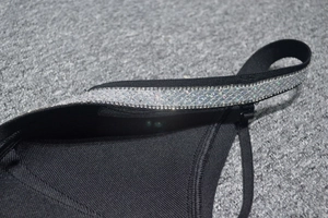 Macro shot of shimmering rhinestone trim on the black backless cocktail bandage dress