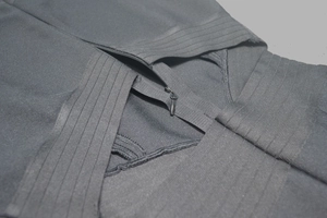 Gros plan de la fermeture éclair invisible sur une combinaison bandage noire sans manches