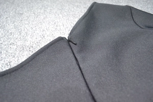Detail of invisible zipper closure on black one-shoulder mesh evening dress