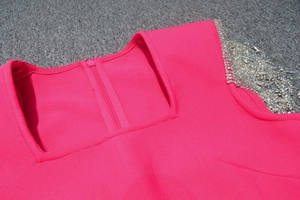 Detail of rose red bandage dress featuring square neck and silver rhinestone fringe tassels