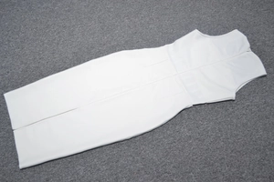 Detailed back view of white sleeveless midi dress with invisible zipper and back slit