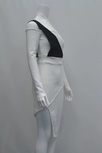 Detailed close-up of asymmetrical hem and black-and-white color block design on a white dress
