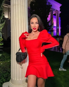 Détail de robe bandage rouge à col carré avec manches bouffantes et jupe à volants