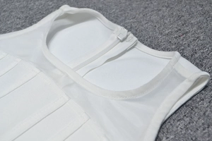 Close-up of white bandage dress neckline featuring mesh patchwork and back zipper
