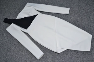 Detail view of monochrome wrap dress with black shoulder straps and asymmetric skirt design