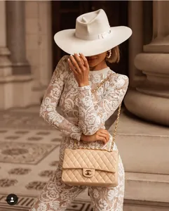 Close-up of beige quilted leather flap bag with chain strap and luxury CC twist lock clasp
