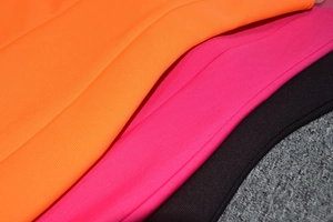 Vue détaillée du tissu en maille côtelée haute densité en orange, rose et noir