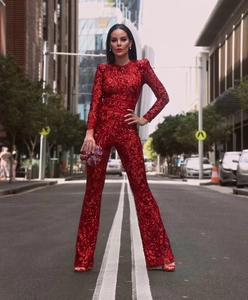 Detail of red sequined jumpsuit featuring lace waist splicing and flared pants