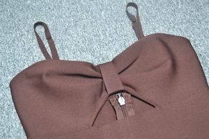 Dettaglio del top bandage marrone a costine con pieghe a fiocco e zip in metallo