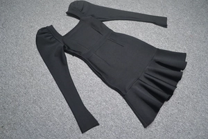 Détail de la robe bandage noire à col carré avec volants plissés et manches bouffantes