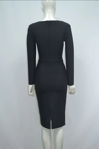 Detail view of the full-length back zipper and slit on a black long-sleeve pencil dress
