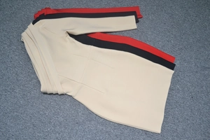 Detail of waist pleats on long-sleeve bodycon dresses in beige, black, and red colors