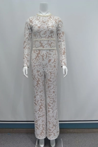 Detailed view of floral lace pattern with sequins and woven pearl waistbands on jumpsuit