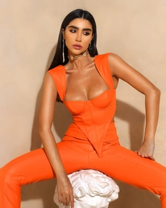 Dettaglio del top a corsetto arancione con scollo quadrato e pantaloni svasati coordinati