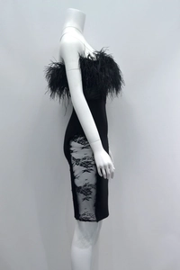 Close-up of black strapless bandage dress featuring feather trim and floral lace panels