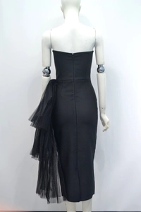 Detailed back view of a slim black strapless evening dress with mesh ruffles and hidden zipper
