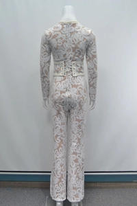 Detail of white sequin lace catsuit showing back cross-bandage design and hidden zipper