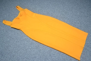 Detail of orange bandage midi dress featuring structured bust and thick shoulder straps