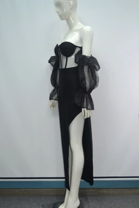 Détail de la robe de soirée noire à manches en mesh et fente haute sur la jambe