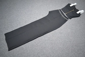 Détail d'un ensemble deux pièces noir avec fermeture éclair dorée et chaîne métallique