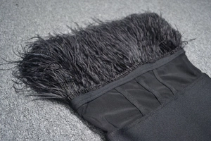 Close-up of black feathers and corset bone structure on a sexy bandage dress