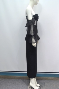 Détail latéral d'une robe de soirée noire avec manches bouffantes en mesh pailleté