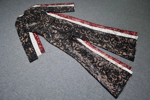 Flat lay of lace sequin jumpsuits in black, red, and beige on a grey carpet background