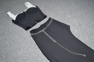 Détail de l'ensemble deux pièces noir avec bretelles blanches et ceinture chaîne argent