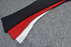 Détails macro des rubans en tissu élastique de robe bandage noir, rouge et blanc