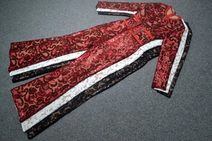 Detailed view of sequined lace jumpsuits in red, white, and black with crisscross waist ties