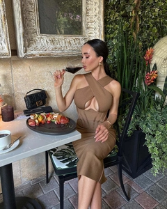 Detailed view of brown halter neck ribbed bandage dress worn in a chic outdoor setting