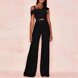 Detail view of black one-shoulder cross-front crop top and high-waist wide-leg pants set
