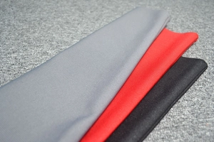 Detail of knitted ribbed fabric in grey, red, and black with soft texture and high elasticity