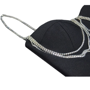 Dettaglio del corpetto di un abito a fascia nero con eleganti catene di strass a strati