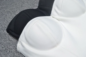 Detailed view of knitted rib fabric and molded cups on black and white corset dresses
